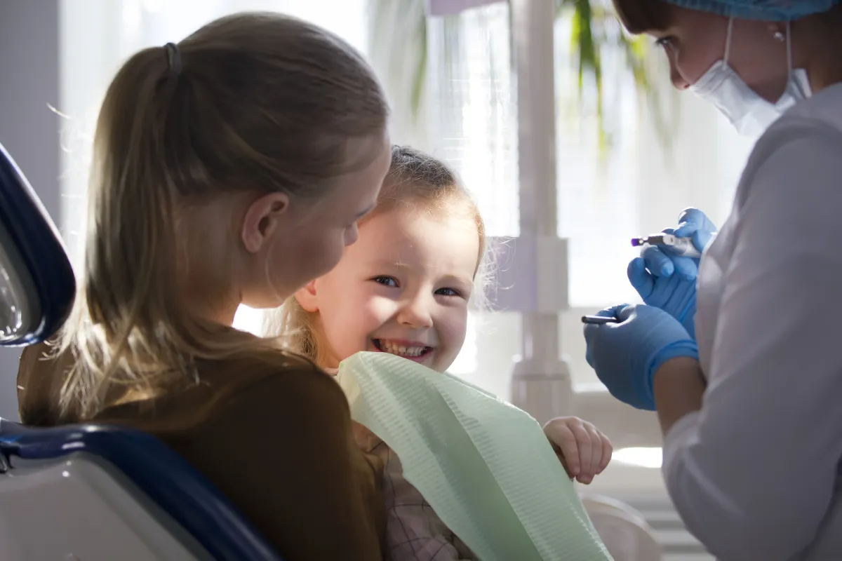 Criança sorrindo em consulta odontológica, contexto de tratamento com expansor palatino infantil
